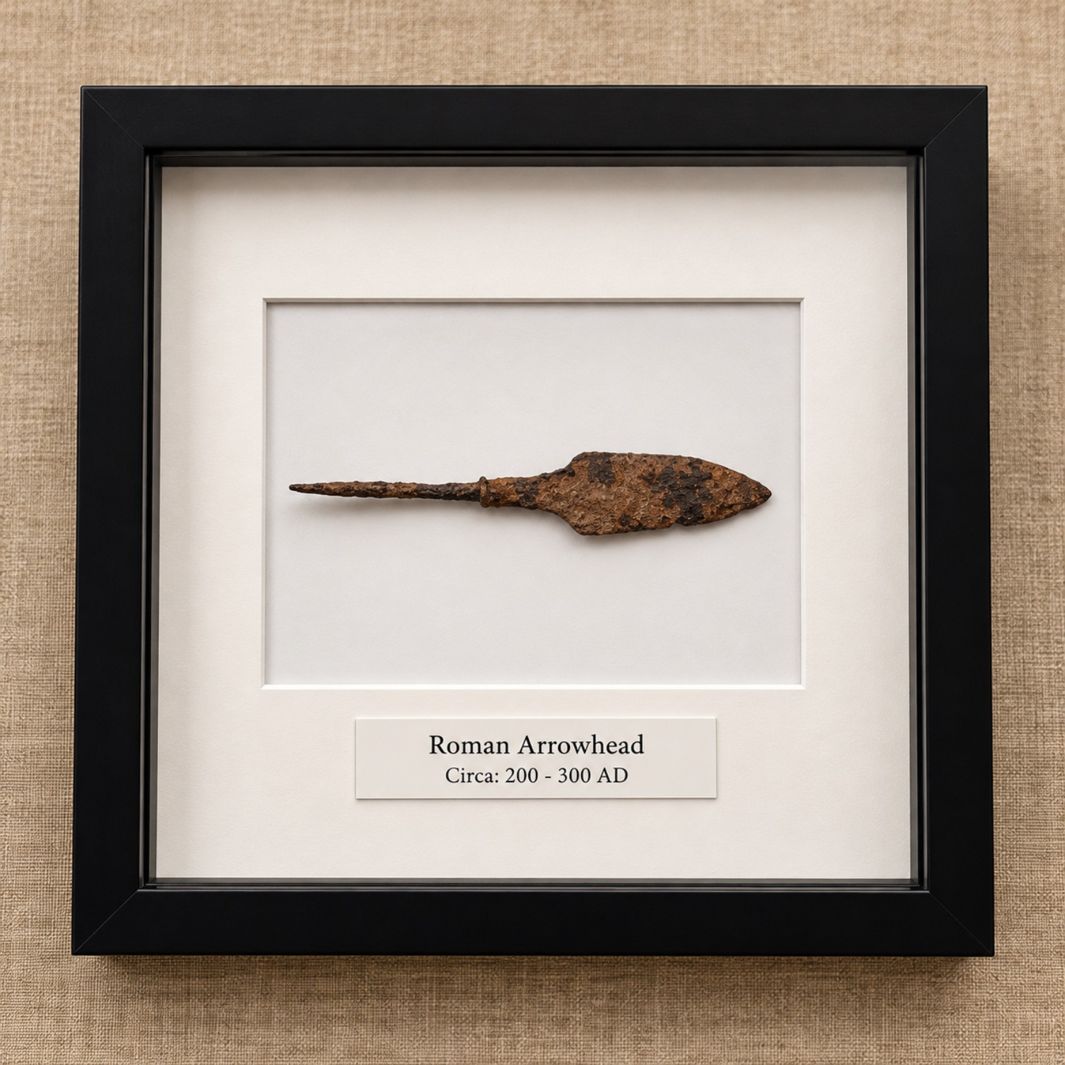 Framed Roman arrowhead display with white mount, black frame and engraved label
